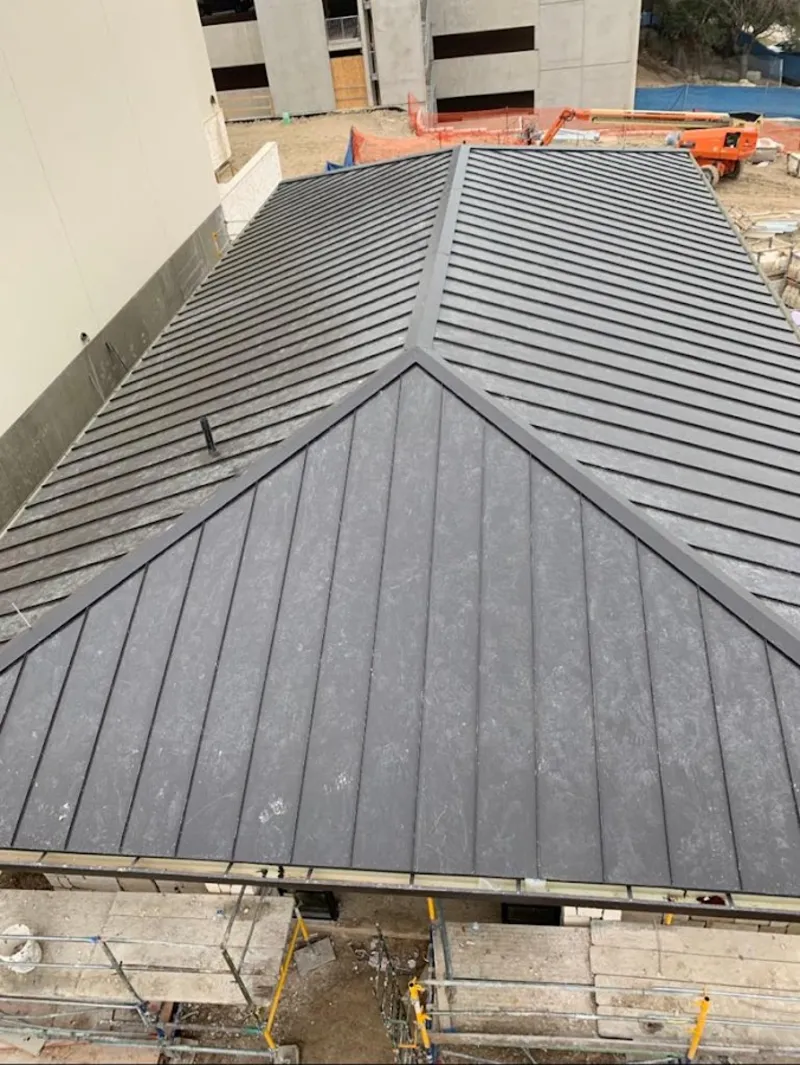 Commercial metal roof construction with crane equipment in Larchmont